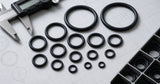 Industrial catalog-style AS568 O-ring size reference concept with assorted black O-rings